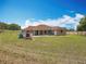 Wide backyard view showing a home with covered patio and a large yard at 13013 County Road 561A, Clermont, FL 34715