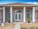 Close-up of the front entrance, featuring decorative pillars, double doors, and stylish lighting at 13013 County Road 561A, Clermont, FL 34715