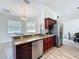 Open kitchen with stainless steel appliances and granite breakfast bar with seating area at 13013 County Road 561A, Clermont, FL 34715