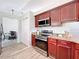Kitchen with stainless steel appliances, granite countertops, and cherry cabinets at 13013 County Road 561A, Clermont, FL 34715