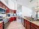 Open kitchen showcasing stainless steel appliances and granite countertops, flowing to living area at 13013 County Road 561A, Clermont, FL 34715