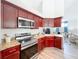 Kitchen with stainless steel oven and microwave, cherry cabinets, and stone countertops at 13013 County Road 561A, Clermont, FL 34715