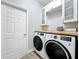 Laundry room featuring a washer and dryer and white cabinets and butcher block countertop at 13013 County Road 561A, Clermont, FL 34715