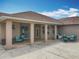 Exterior view of a covered patio with dining and seating area with access to a large backyard at 13013 County Road 561A, Clermont, FL 34715