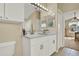 Well-lit bathroom with double vanity, white cabinets, and tiled floors at 1313 Lake Idamere Blvd, Tavares, FL 32778