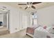 Bright bedroom features plush carpeting, ceiling fan, and a serene view from the window at 1313 Lake Idamere Blvd, Tavares, FL 32778