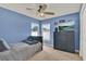 Blue bedroom offers natural light, neutral carpet, and a ceiling fan at 1313 Lake Idamere Blvd, Tavares, FL 32778