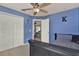 Blue bedroom features a ceiling fan, large closet, and entry to another room at 1313 Lake Idamere Blvd, Tavares, FL 32778