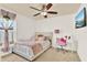A charming bedroom with a ceiling fan, cozy decor, and desk with a cute pink chair at 1313 Lake Idamere Blvd, Tavares, FL 32778