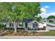 Inviting single-story home featuring well-maintained landscaping and a shade tree at 1313 Lake Idamere Blvd, Tavares, FL 32778