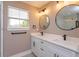 Bright bathroom showcasing a double vanity with modern fixtures, and natural light from a window at 1336 Crystal Lake E Ave, Orlando, FL 32806