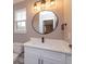 Elegant bathroom featuring a modern vanity with quartz countertop and a sleek, round mirror at 1336 Crystal Lake E Ave, Orlando, FL 32806