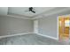 Spacious bedroom with tray ceilings, a ceiling fan, and neutral walls and floors, creates a calming atmosphere at 1336 Crystal Lake E Ave, Orlando, FL 32806