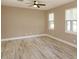 A sunlit bedroom features wood floors, two windows and a ceiling fan at 1336 Crystal Lake E Ave, Orlando, FL 32806