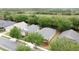 Neighborhood aerial view showing mature landscaping, manicured lawns and homes with gray shingled roofs at 135 Crepe Myrtle Dr, Groveland, FL 34736