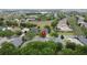 Aerial view showing houses with large yards and mature landscaping with nearby lake in distance at 135 Crepe Myrtle Dr, Groveland, FL 34736