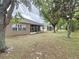 Backyard featuring grass and trees with enclosed lanai at 135 Crepe Myrtle Dr, Groveland, FL 34736