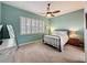 This bedroom features a ceiling fan, shuttered windows and carpet flooring at 135 Crepe Myrtle Dr, Groveland, FL 34736