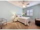 Charming bedroom with a ceiling fan, light blue walls, and a bright window at 135 Crepe Myrtle Dr, Groveland, FL 34736