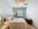 Comfortable bedroom with bright light, white bedding, and neutral carpet at 135 Crepe Myrtle Dr, Groveland, FL 34736