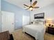 Cozy bedroom with a ceiling fan, a comfortable bed and neutral carpet flooring at 135 Crepe Myrtle Dr, Groveland, FL 34736
