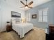 Cozy bedroom with a ceiling fan, side tables, and plantation shutters at 135 Crepe Myrtle Dr, Groveland, FL 34736