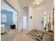 Bright foyer features tile flooring, a decorative rug, and a console table with a mirror, creating a welcoming entrance at 135 Crepe Myrtle Dr, Groveland, FL 34736