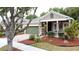 Inviting single-story home featuring a landscaped yard, a welcoming porch, and a charming, light-green garage door at 135 Crepe Myrtle Dr, Groveland, FL 34736