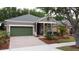 Inviting single-Gathering home with a covered porch, attached garage, and a brick-paved driveway, adding to its charm at 135 Crepe Myrtle Dr, Groveland, FL 34736
