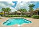 Inviting hot tub and community pool area featuring lush landscaping, palm trees, and clubhouse at 135 Crepe Myrtle Dr, Groveland, FL 34736