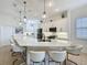 Spacious kitchen featuring white cabinets, stainless steel appliances, and a large center island with seating at 135 Crepe Myrtle Dr, Groveland, FL 34736