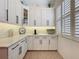 Bright kitchen featuring white cabinets, a decorative backsplash, and lovely plantation shutters at 135 Crepe Myrtle Dr, Groveland, FL 34736