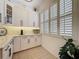 This bright kitchen features white cabinets, a stylish backsplash, and elegant plantation shutters at 135 Crepe Myrtle Dr, Groveland, FL 34736