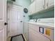 Bright laundry room with white cabinets, appliances and tile flooring at 135 Crepe Myrtle Dr, Groveland, FL 34736
