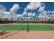 Well-maintained tennis courts with nets, green surface, and shaded seating areas for residents' enjoyment at 135 Crepe Myrtle Dr, Groveland, FL 34736