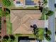 An aerial view shows the roof of the property, and a brick driveway complemented by lush green landscaping at 1408 Deuce Cir, Davenport, FL 33896