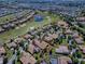 Aerial view featuring the scenic golf course community, with lakes, greens, and beautiful homes, for a serene environment at 1408 Deuce Cir, Davenport, FL 33896