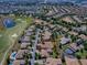 Aerial view showcasing the golf course community, complete with water features and lush landscaping surrounding well-maintained homes at 1408 Deuce Cir, Davenport, FL 33896