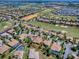 An aerial view shows the golf course community, lakes, and home with beautiful landscaping and a well-maintained neighborhood at 1408 Deuce Cir, Davenport, FL 33896