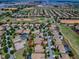 An aerial view shows a golf course community with homes, green landscaping, and a street view of the neighborhood at 1408 Deuce Cir, Davenport, FL 33896