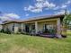 Beautiful backyard featuring a covered patio, lush green lawn, and meticulous landscaping with a garden at 1408 Deuce Cir, Davenport, FL 33896