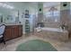 Bright bathroom featuring a tiled tub, dual entry shower, tile floor, and green accents at 1408 Deuce Cir, Davenport, FL 33896