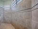 Walk-in tiled shower with a rain shower head, accent tiling, and a shower window at 1408 Deuce Cir, Davenport, FL 33896