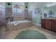 Bright bathroom featuring a tiled tub, dual entry shower, tile floor, and green accents at 1408 Deuce Cir, Davenport, FL 33896