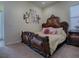 Elegant bedroom featuring a large ornate bed, neutral walls adorned with decorative crosses, and plush carpet at 1408 Deuce Cir, Davenport, FL 33896