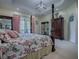 Comfortable bedroom featuring a floral comforter, four poster bed, and natural light from the sliding glass doors at 1408 Deuce Cir, Davenport, FL 33896