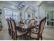 Formal dining room featuring a polished wood table set for a meal, lit by elegant chandelier lighting at 1408 Deuce Cir, Davenport, FL 33896