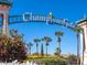 Scenic view of the ChampionsGate entrance sign framed by lush landscaping and palm trees at 1408 Deuce Cir, Davenport, FL 33896