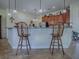 Kitchen featuring granite countertops, wood cabinets, and bar stool seating at 1408 Deuce Cir, Davenport, FL 33896