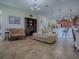 Inviting living room with tile flooring open to kitchen and dining area with traditional furnishings and finishes at 1408 Deuce Cir, Davenport, FL 33896